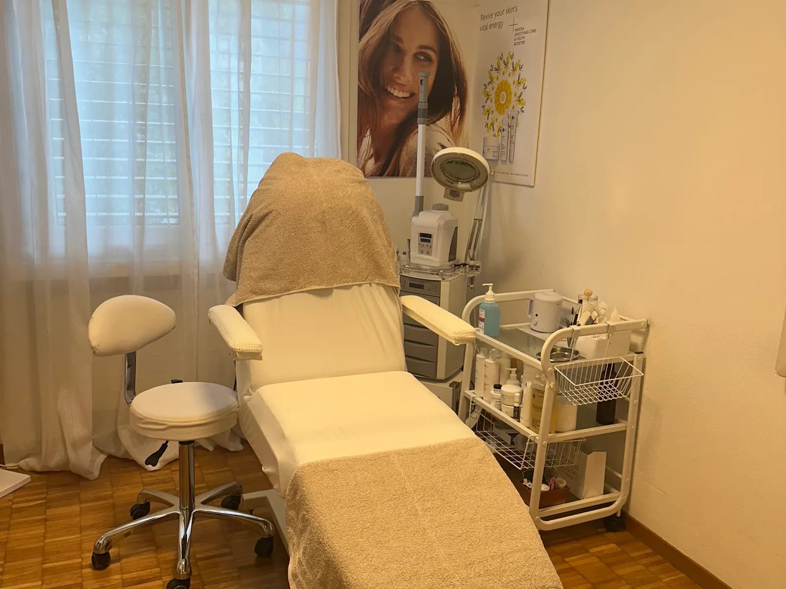 Treatment room with beauty couch, steamer and care trolley by the window